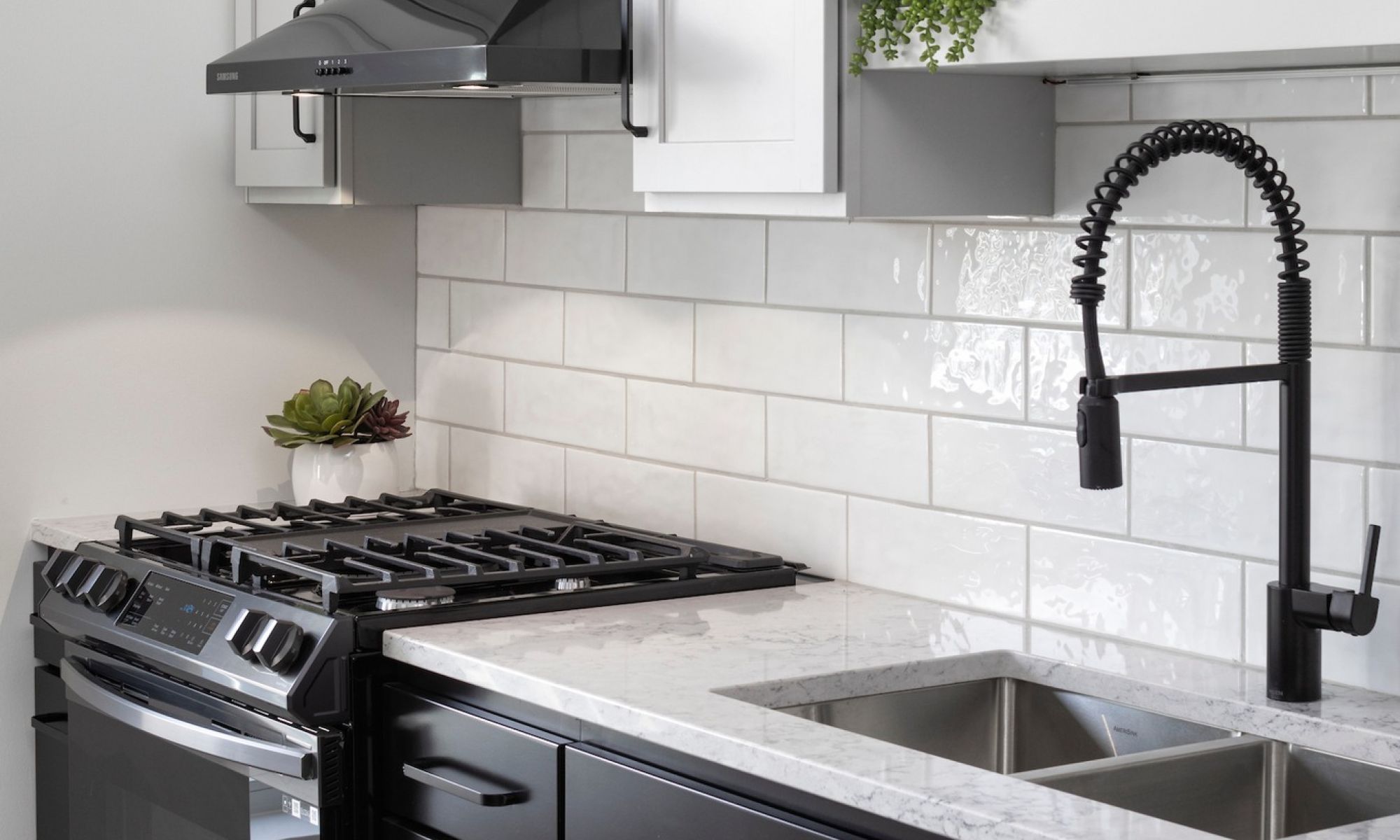 Close up of kitchen tile backsplash, oven, and sink in Minneapolis penthouse apartment