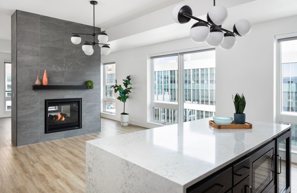Moment Apartments penthouse dining area with double sided fireplace and designer lighting